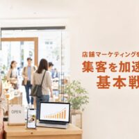 来店客でにぎわう店舗に立つ日本人オーナーと、集客数の増加を示すグラフ、「店舗マーケティングを成功させる!集客を加速させる基本戦略」の文字を配置した画像