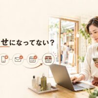 美容・ライフスタイル店舗でスマートフォンとパソコンを確認する日本人女性店主と、「集客、運任せになってない?」の文字、検索から来店までの流れを配置した画像
